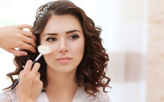 Maquilleuse en train de maquiller une mariée avant la cérémonie