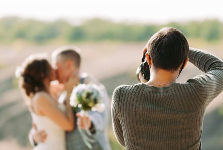 Photographe de mariage photographiant les mariés en pleine nature en automne