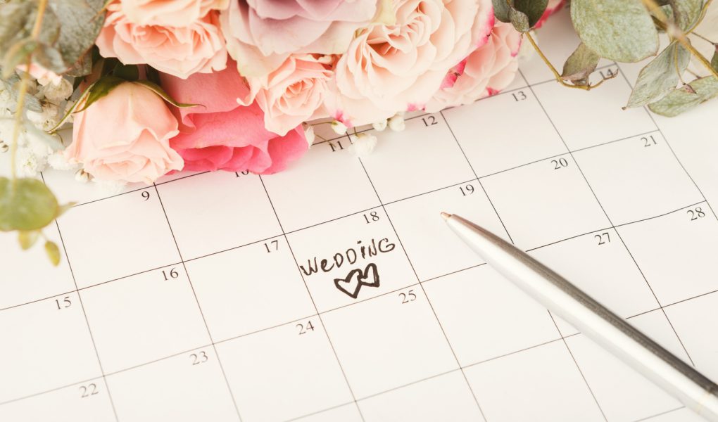 Calendrier avec le mot wedding entouré de fleurs pour planifier un mariage en 2027